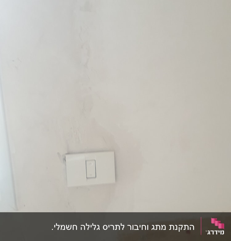 מתג חשמל על קיר לבן עם טיח מתקלף